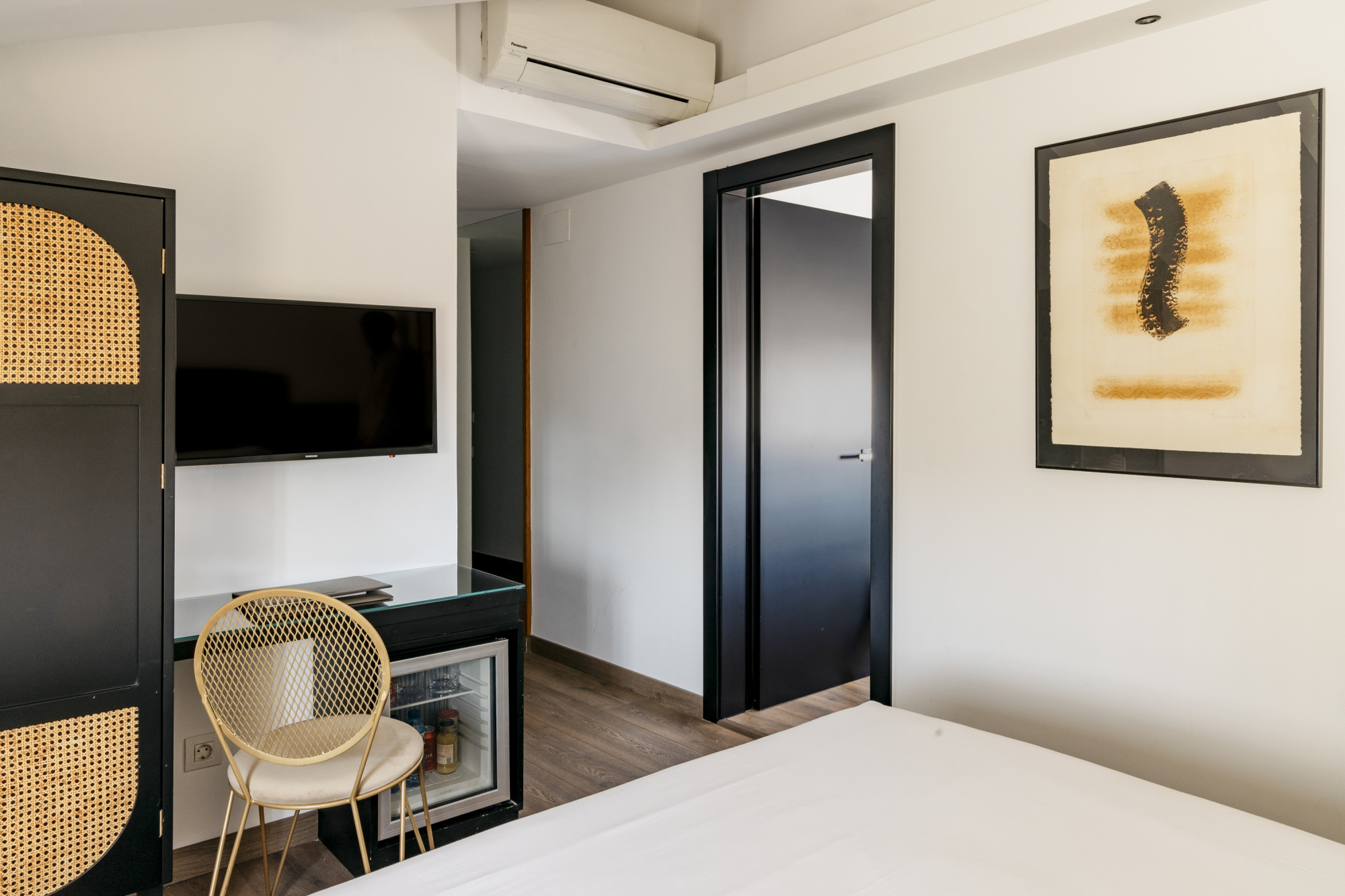 Imagen que muestra una habitación de hotel moderna y acogedora, con decoración en tonos neutros y mobiliario contemporáneo.