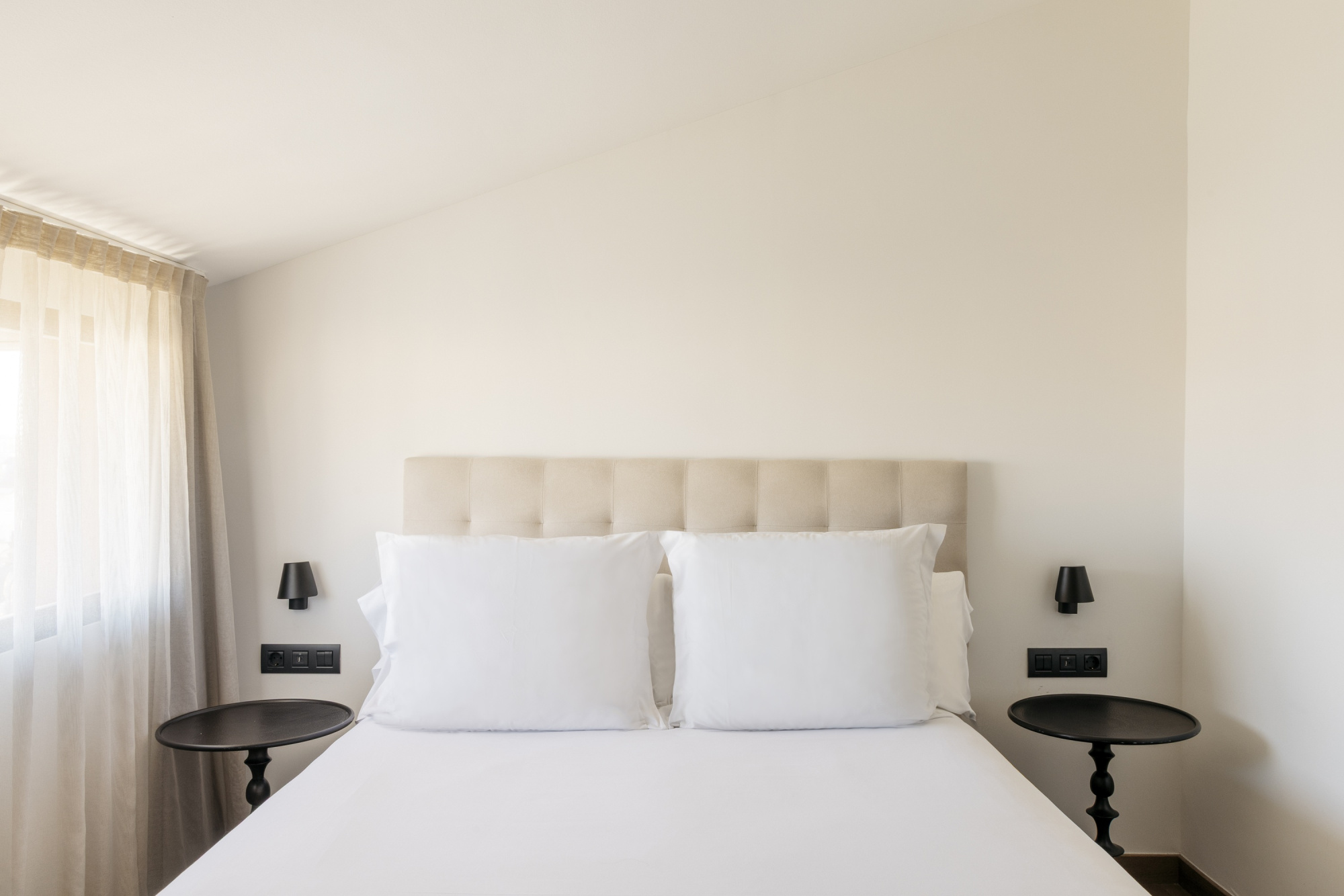 Una habitación de hotel moderna con decoración elegante y mobiliario cómodo, diseñada para ofrecer una estancia confortable.