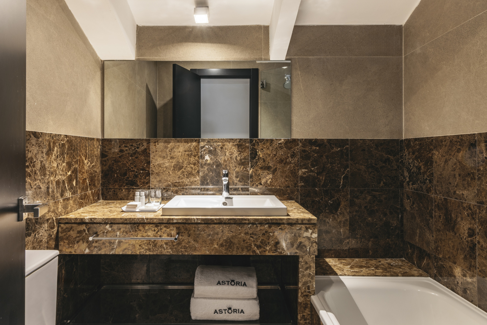 Una habitación de hotel moderna y acogedora con decoración en tonos neutros y mobiliario cómodo, diseñada para ofrecer una estancia confortable.