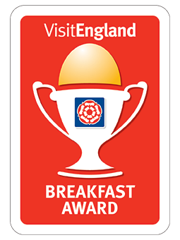 Sello rojo y blanco con el texto VisitEngland Breakfast Award y un trofeo en el centro.