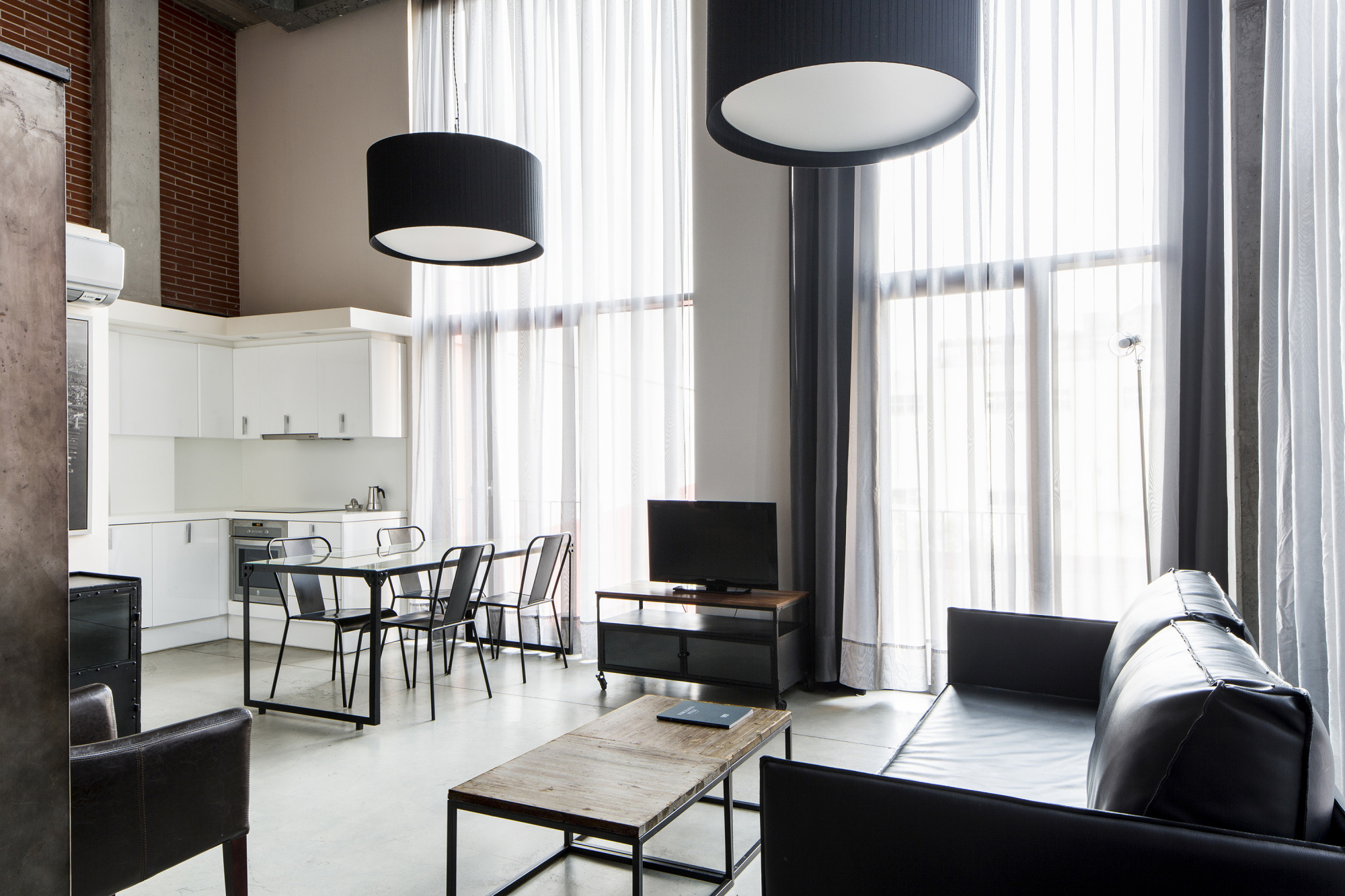 El salón dispone de sofá, mesa de centro, chimenea eléctrica y una cocina integrada junto a la zona de comedor.