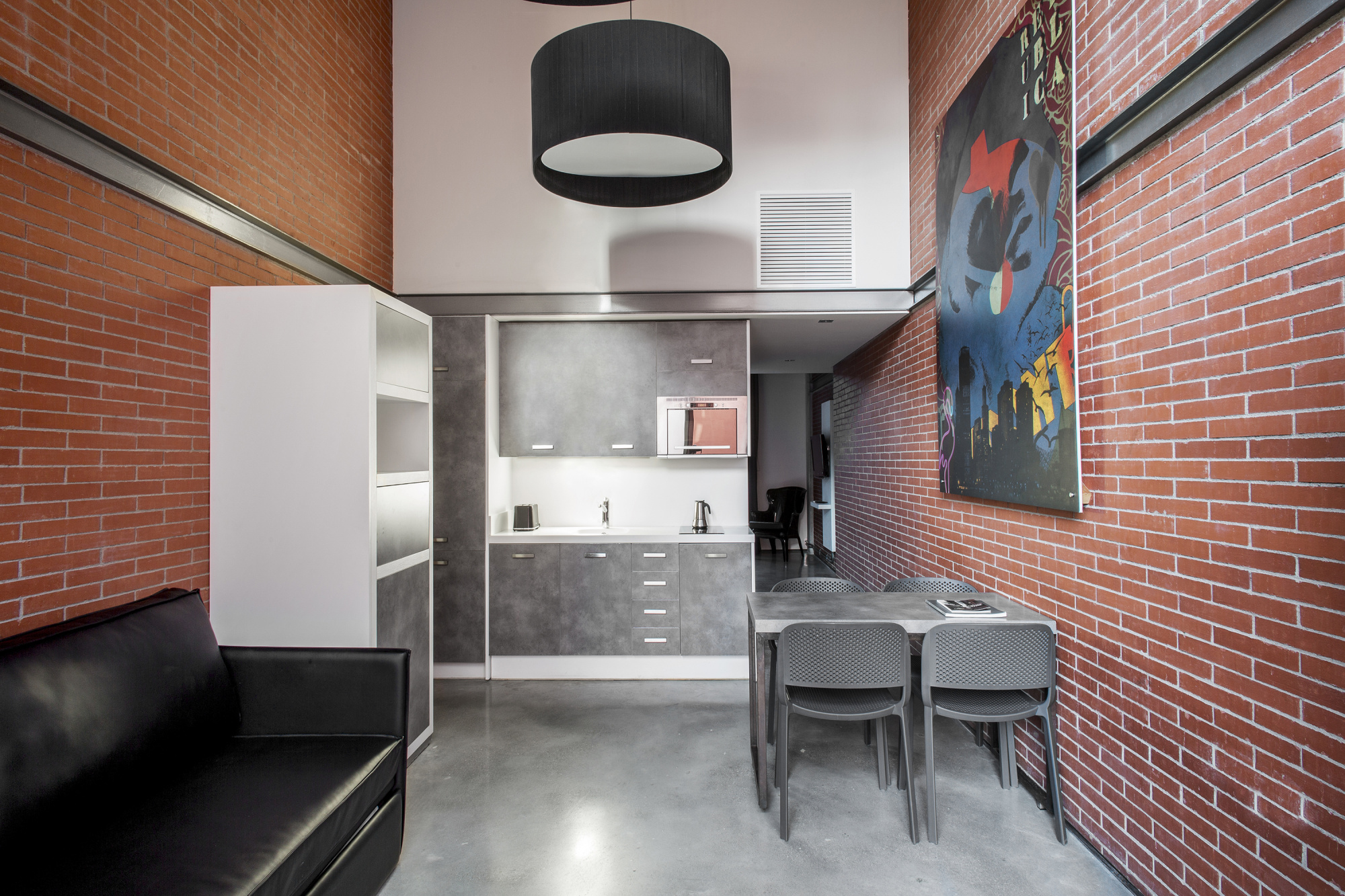 Se ve una zona de comedor con dos sillas y una cocina integrada con encimera y fregadero.