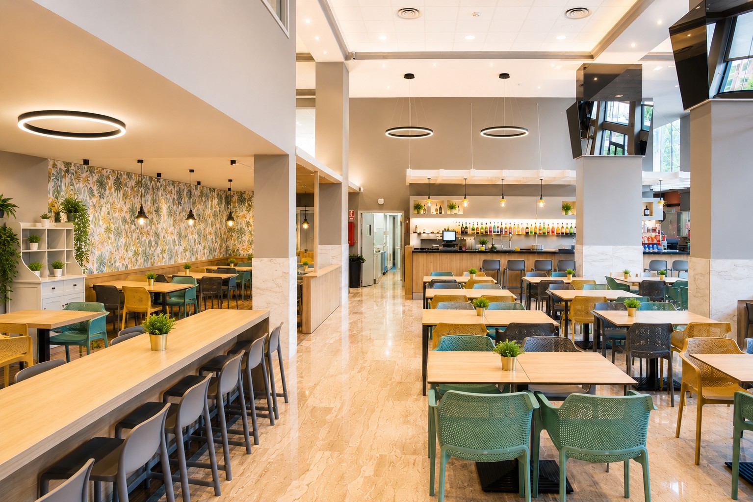 Se ve un bar con barra iluminada y mesas con sillas en un comedor interior.