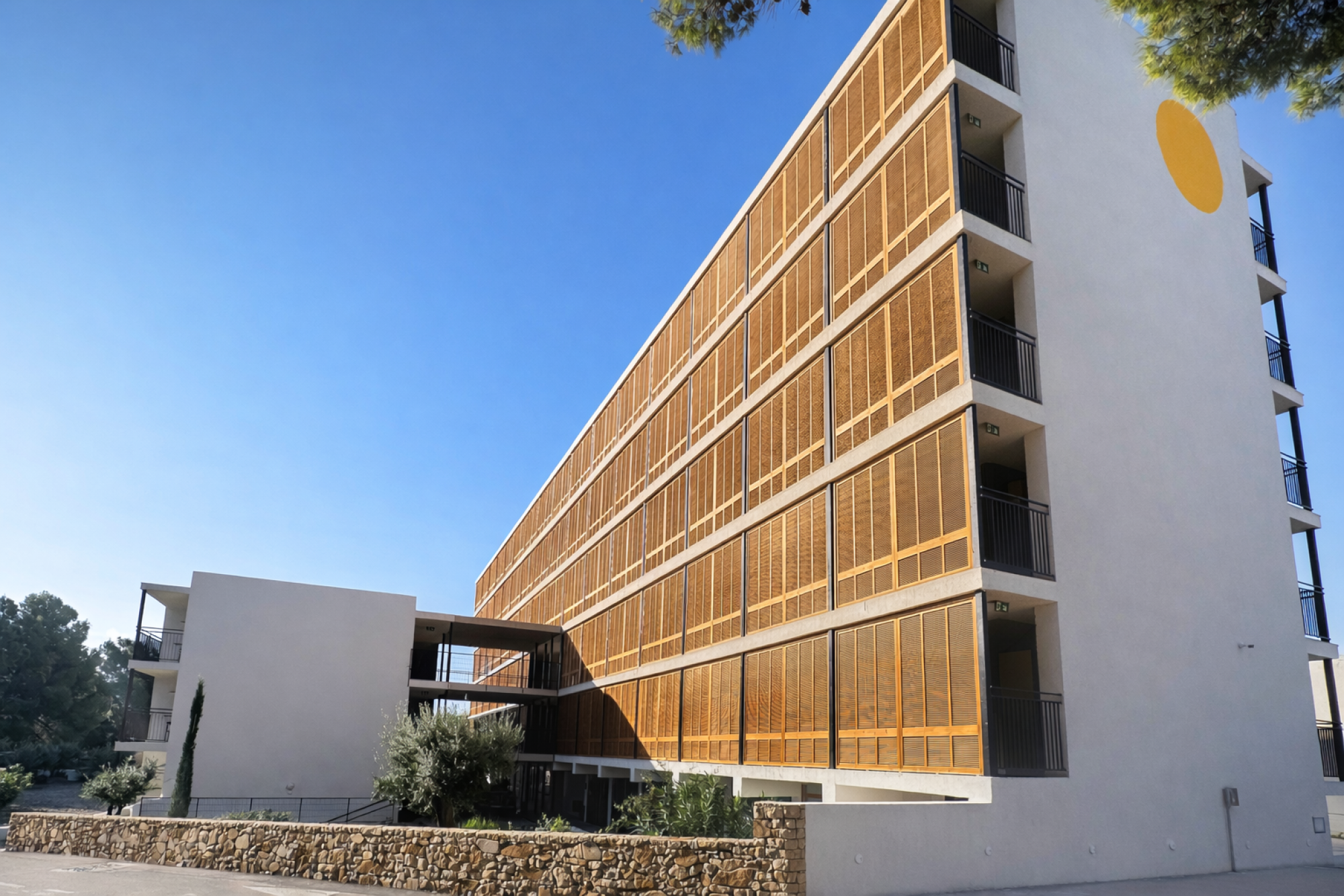 Imagen de la fachada de un hotel con un diseño moderno y colores vibrantes, que transmite una bienvenida cálida y atractiva.