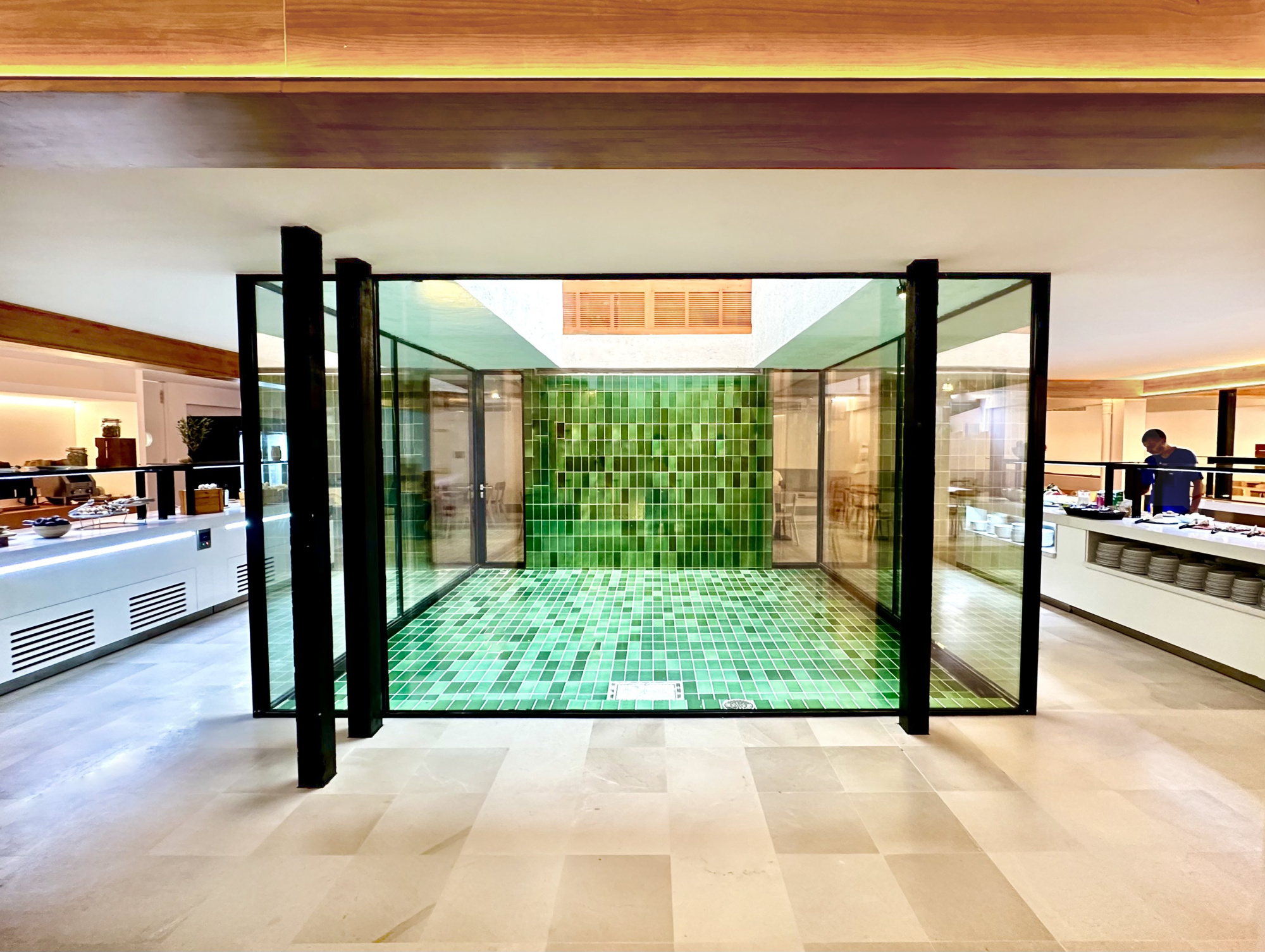 Una vista de un interior de hotel con mobiliario moderno y elegante, destacando colores neutros y detalles decorativos sutiles.