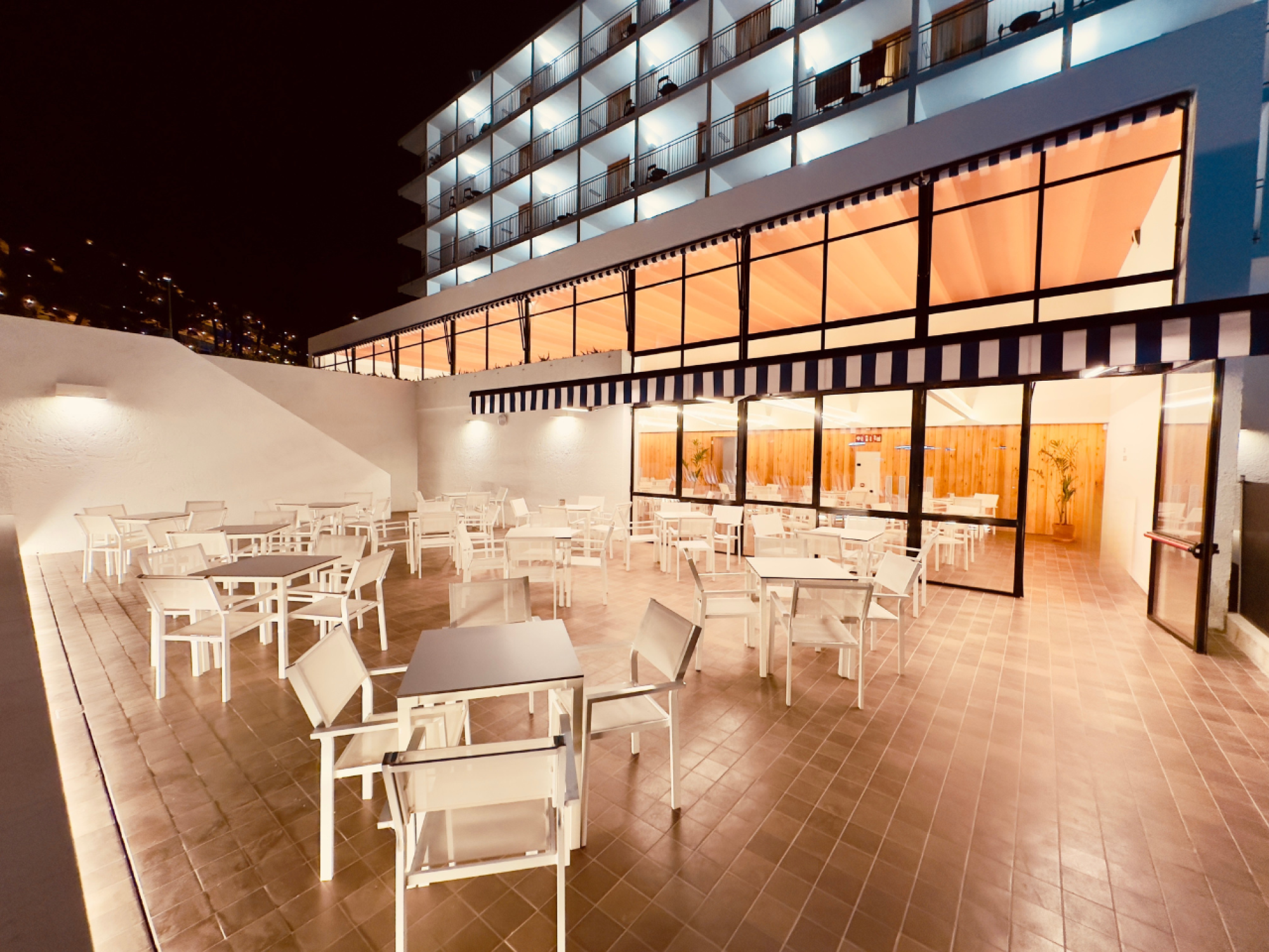 Imagen del exterior del Sun Club Hotel Cala Vinya, mostrando una estructura moderna con áreas de descanso y vegetación alrededor, en un entorno costero.