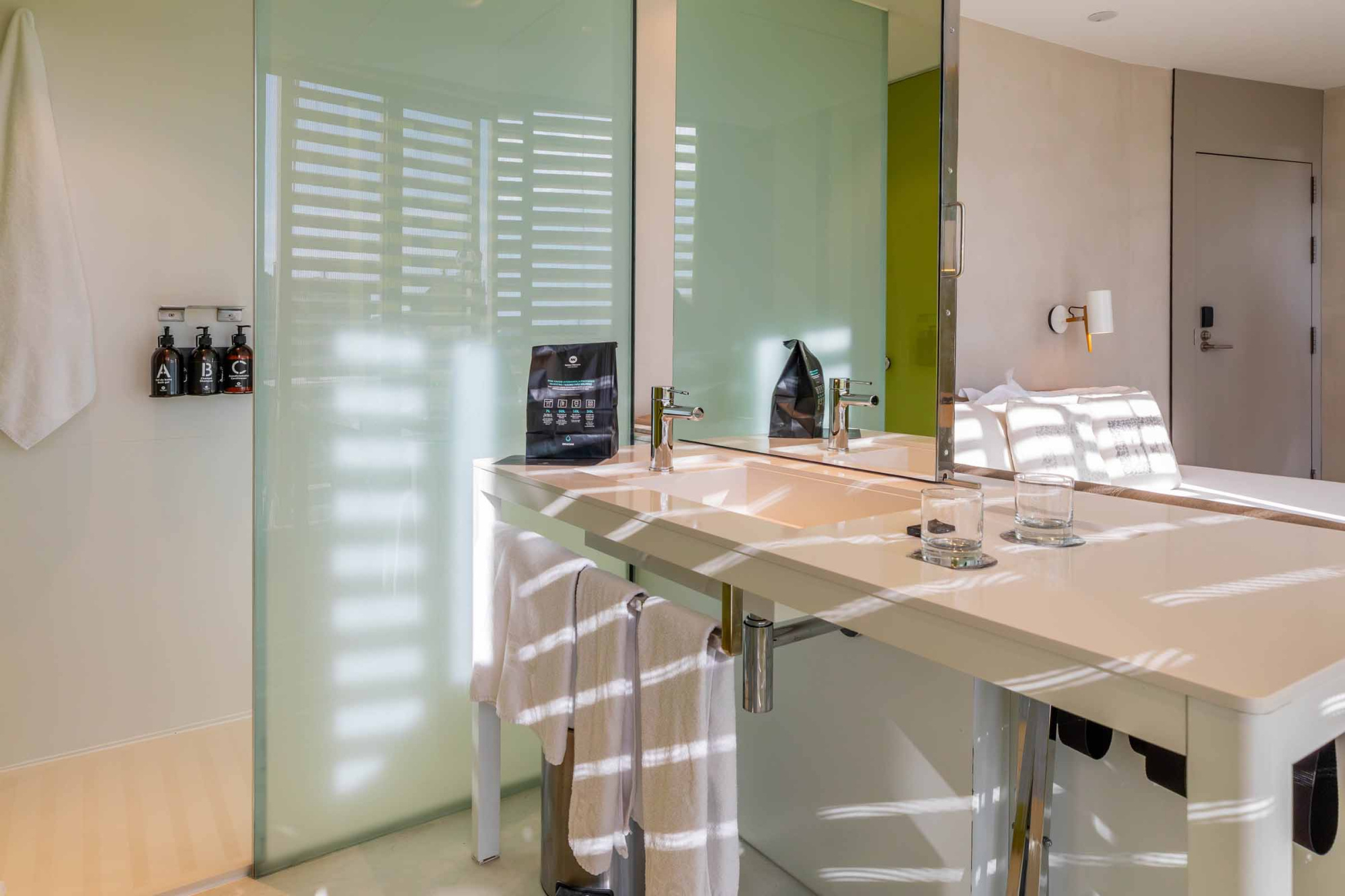 Se ve una mesa de comedor con sillas y una pared verde con una puerta al fondo.