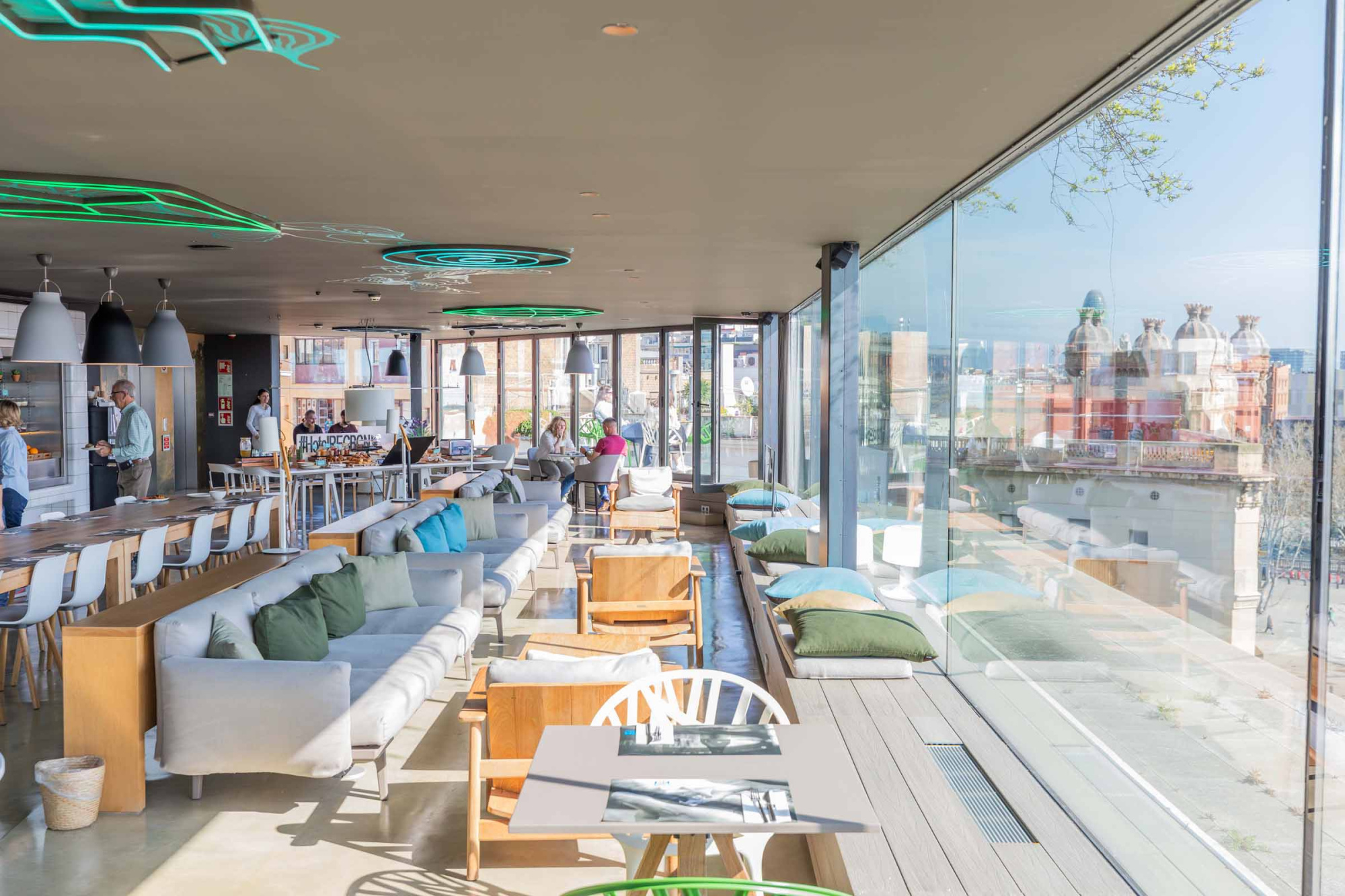 La terraza muestra mesas y sillas junto a un ventanal con luz natural.