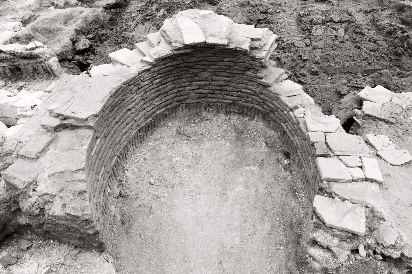 Se ve la entrada de un túnel de piedra con piedras alrededor en un entorno excavado.