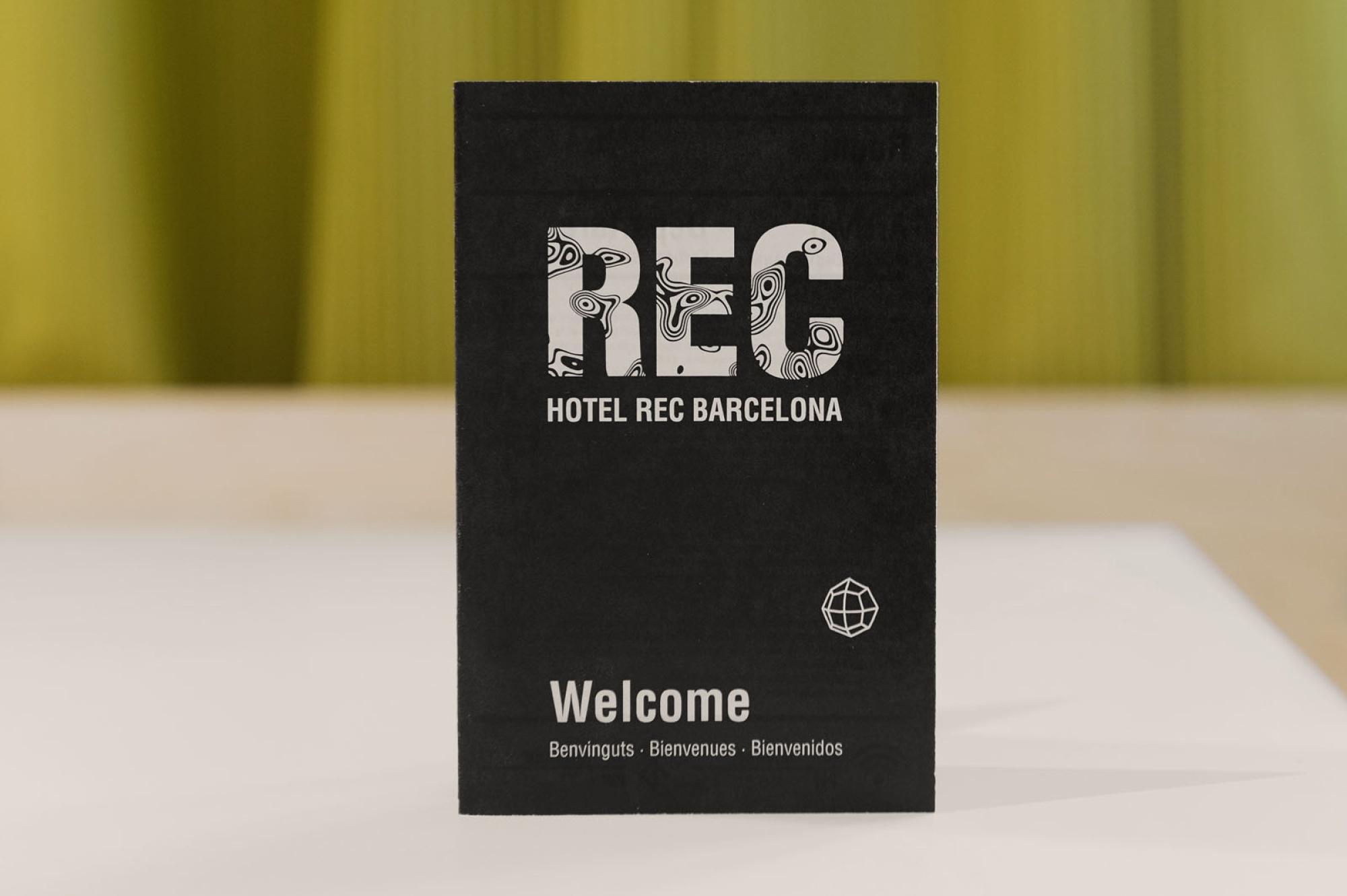 Se ve un cartel negro de bienvenida con el texto “REC” y “Hotel REC Barcelona”.