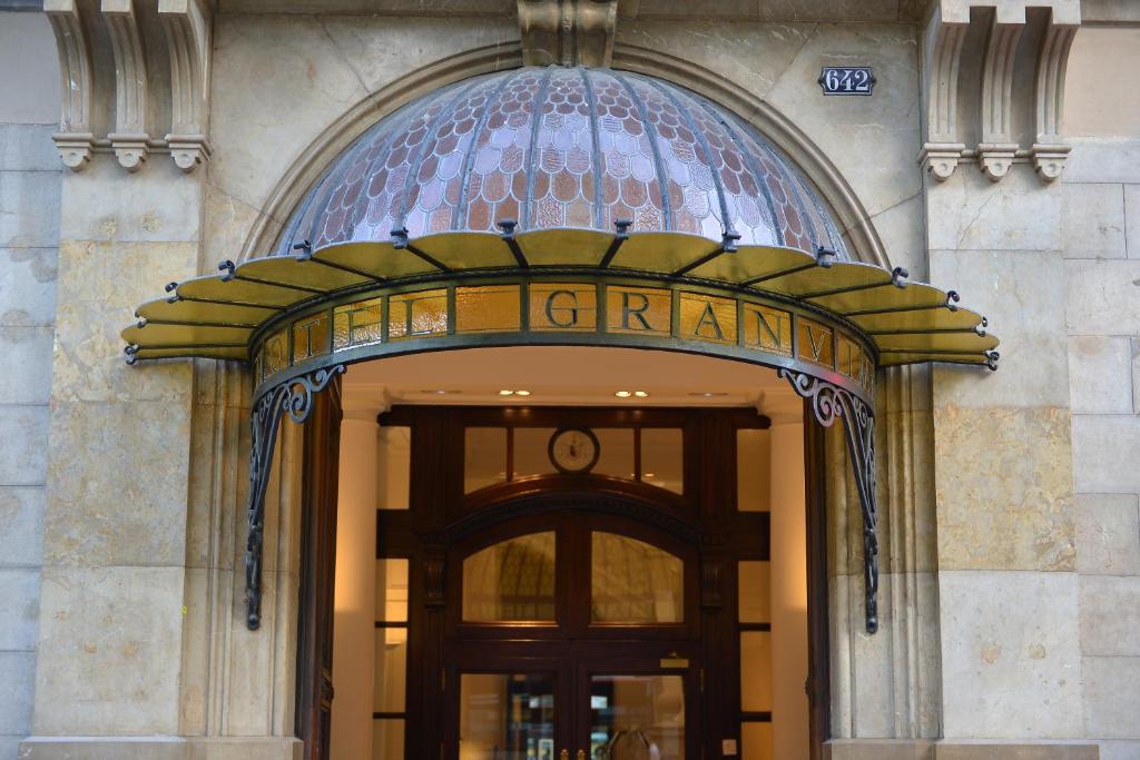 Entrada de un edificio histórico con marquesina y acceso principal en la fachada del hotel.