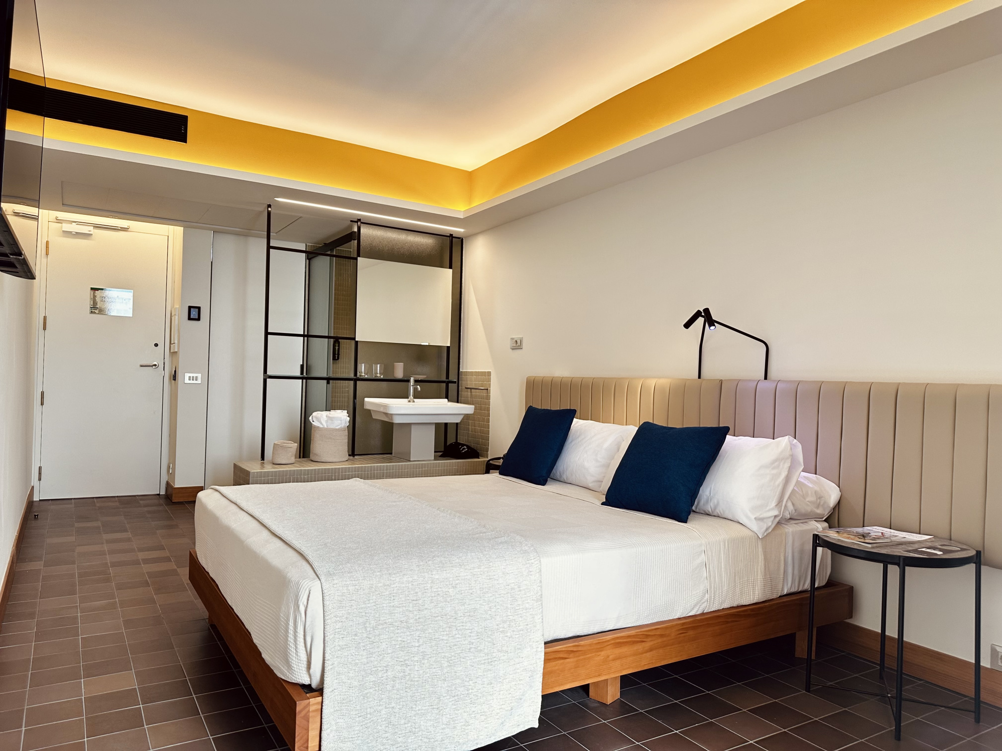 Habitación elegante con decoración moderna, en tonos neutros y detalles en madera, que ofrece un ambiente cómodo y acogedor para los huéspedes.