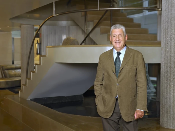 Jordi Clos posa junto a una zona de recepción con escaleras y barandillas de metal en el interior.