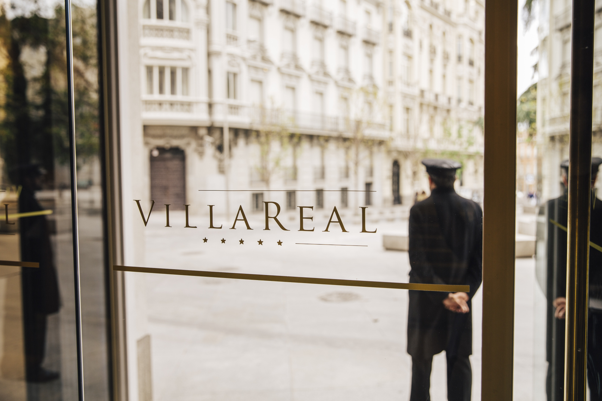Se ve el rótulo “VILLAREAL” en la entrada con una figura al fondo y un edificio de estilo clásico detrás.