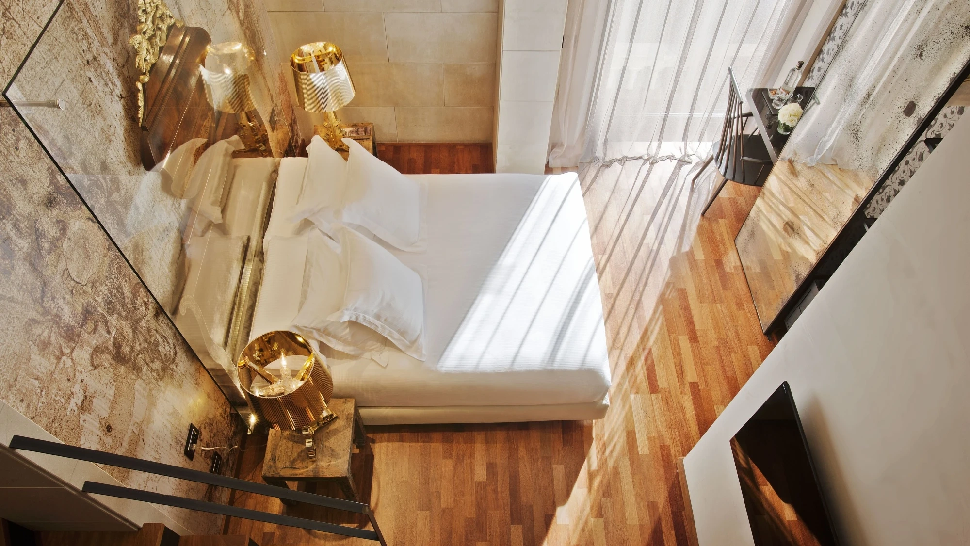 Habitación de lujo tipo suite dúplex con decoración moderna y elegante, con tonos neutros y detalles sofisticados que ofrecen un ambiente cómodo y exclusivo.