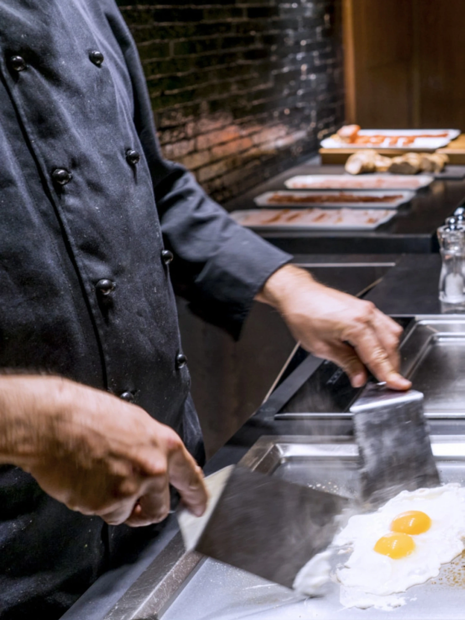 Una variedad de alimentos en un buffet de desayuno, incluyendo frutas, panes y otros productos, presentado en un entorno luminoso y acogedor.