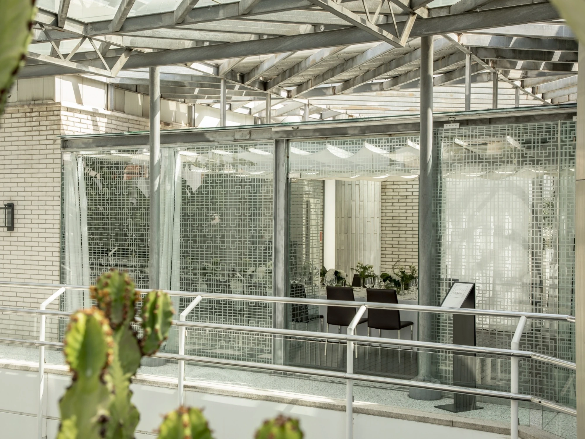 Una imagen que muestra un espacio de banquete al aire libre con mesas decoradas y sillas, rodeado de vegetación y árboles, ideal para eventos y celebraciones en un entorno natural.