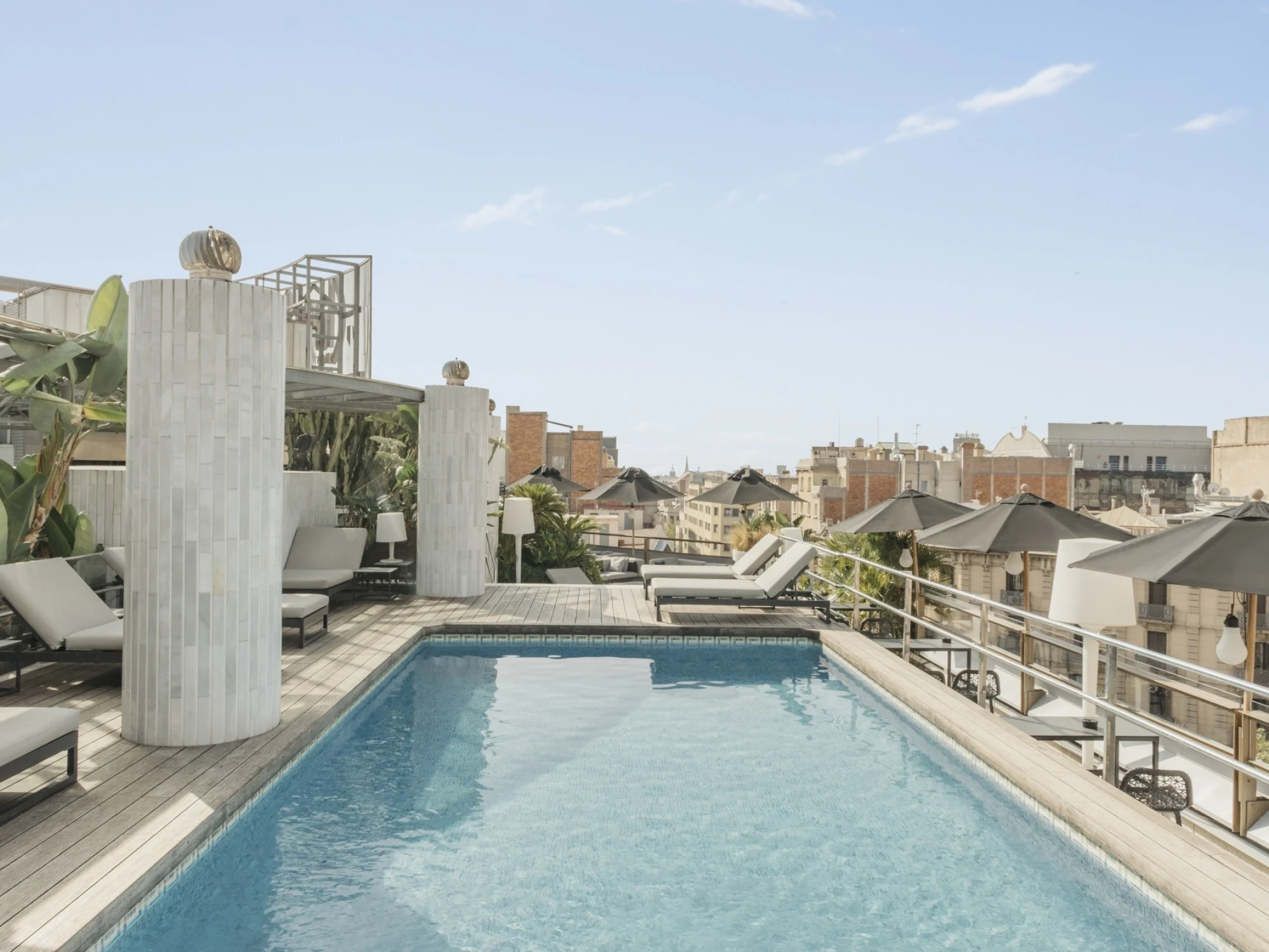 Una piscina moderna y elegante con agua azul clara, rodeada de un entorno relajante que invita al descanso y la diversión.
