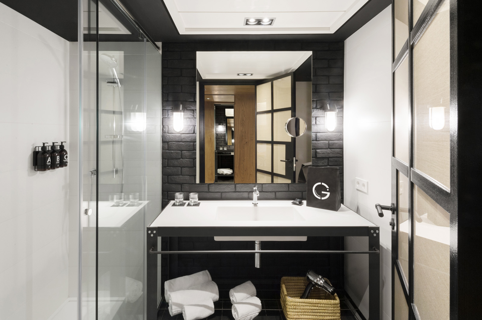 Baño moderno con lavabo doble, espejo y ducha de cristal con mampara.