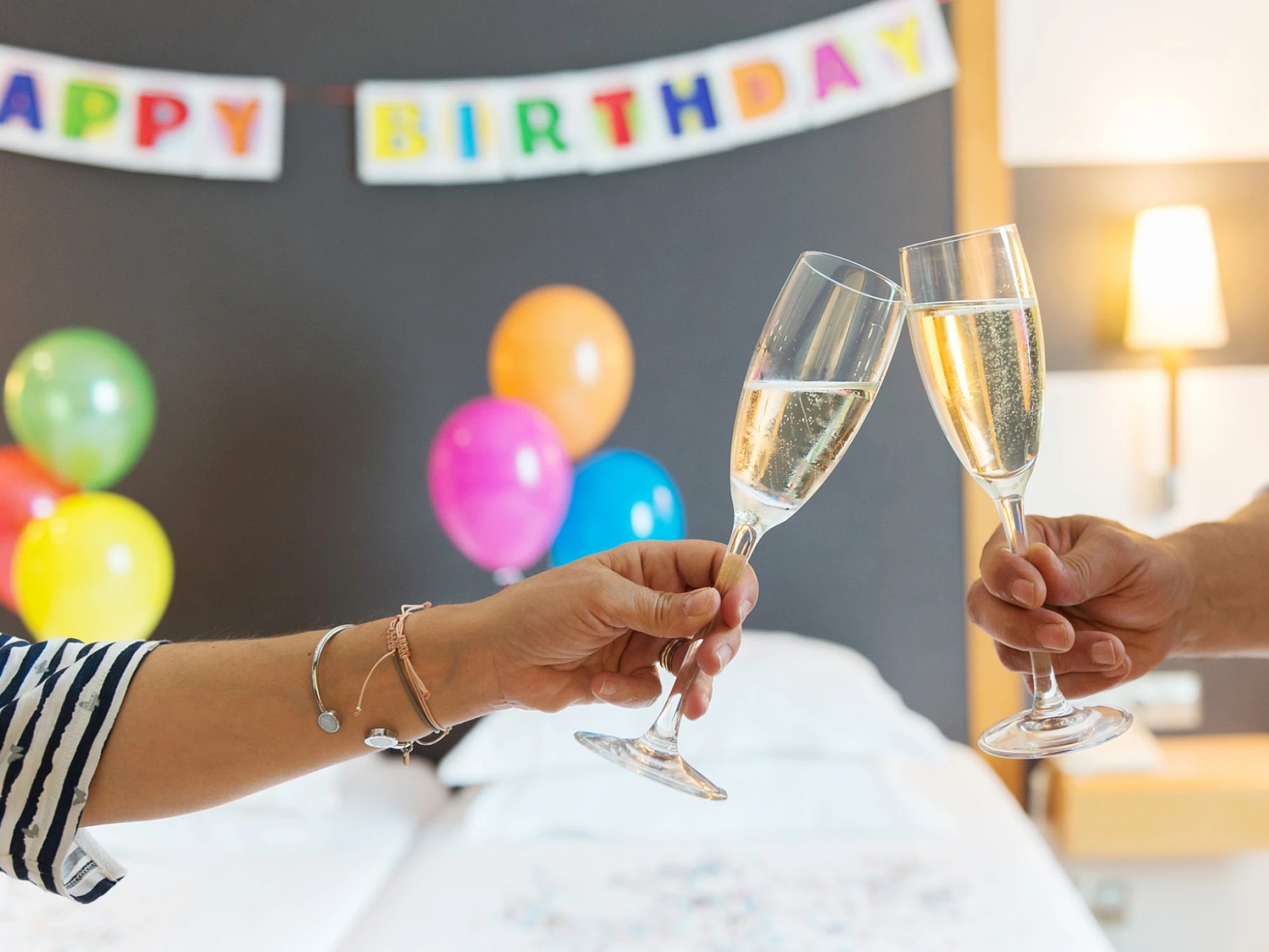 Varias copas de champán y globos decoran una mesa preparada para una celebración de cumpleaños.